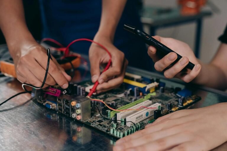 Two electricians repair a board.