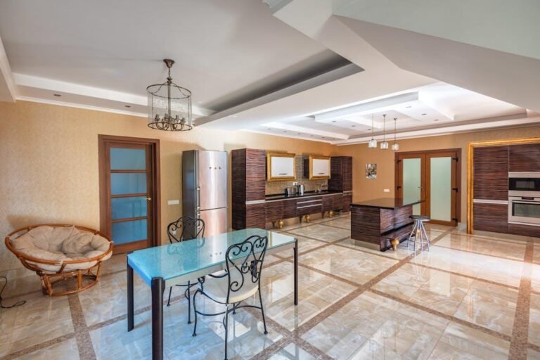 Elegant dining and kitchen area with layered ceiling lighting and decorative pendant fixtures