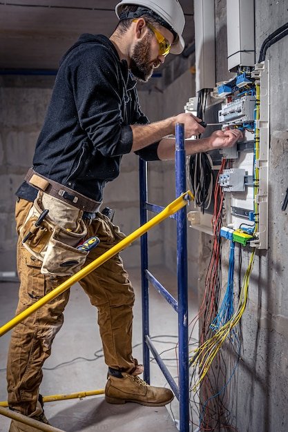 Licensed electrician inspecting and working inside a residential electrical panel