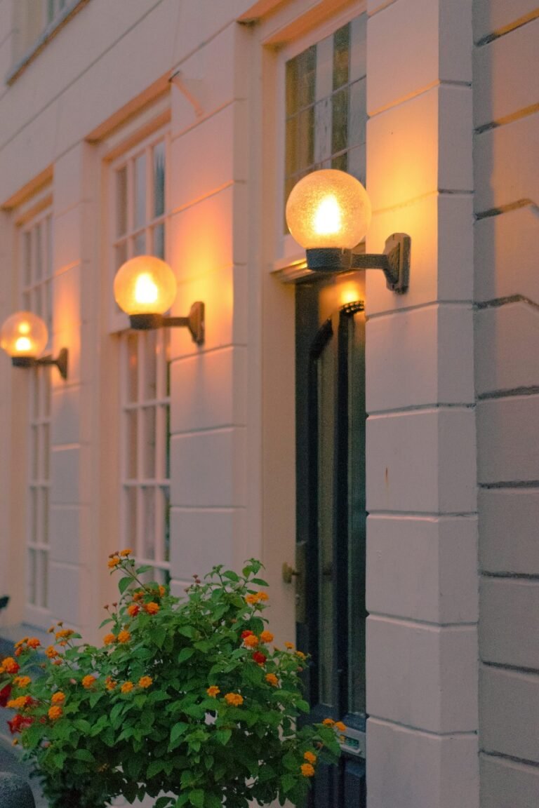 Bright home entrance illuminated by three wall lamps.