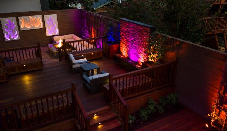 LED landscape lighting design illuminating modern backyard deck and