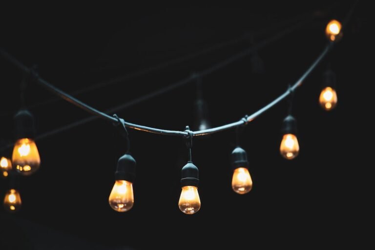 Warm outdoor string lights suspended against a dark evening sky