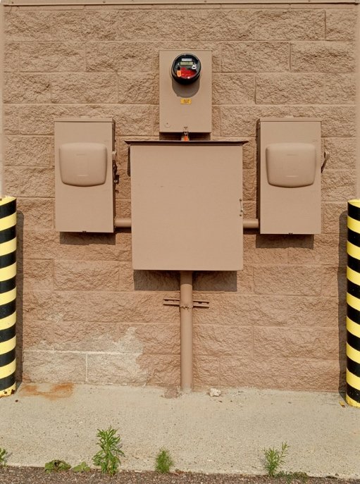 weatherproof outdoor electrical outlet with protective cover installed on exterior wall