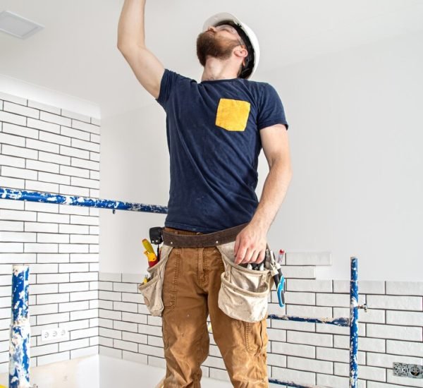 electrician-builder-work-installation-lamps-height-professional-overalls-with-drill-background-repair-site